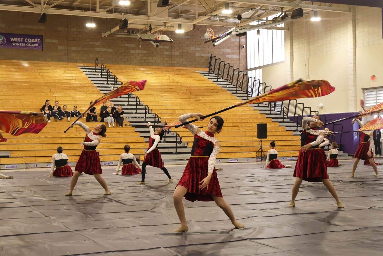 Color guard member and freshman Leia Speir performs during the flag feature, a piece of the show in which 25 members twirl their flags and dance in synchronization. Speir said that prior to each competition, the team has to go through a multi-hour long process of hair, makeup and final practices.