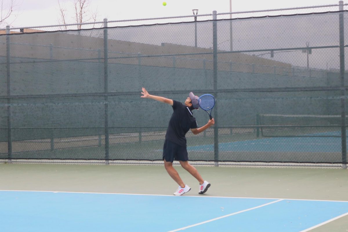  Doubles player and sophomore Aditya Joshi tosses the ball into the air in preparation to serve during the second set. Joshi and his partner, junior Smaran Mallojula, won the set 6-2. “I think overall the team did pretty good,” singles player and sophomore Anthony Nguyen said. “I’m pretty happy with the outcome.”