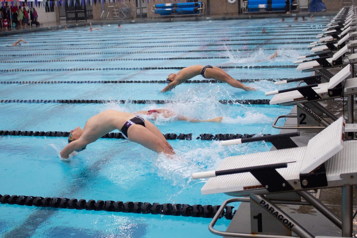 Varsity swimmer and senior Gavin Nicholson executes a backstroke start into the boys’ 200-yard medley relay. This season, the team aims to focus on boosting their overall spirit through bonding activities, such as beach practices and a bonfire, according to head coach Steven Richards. “We have a really good, strong team spirit on our team, Richards said. “I want to see that continue.”