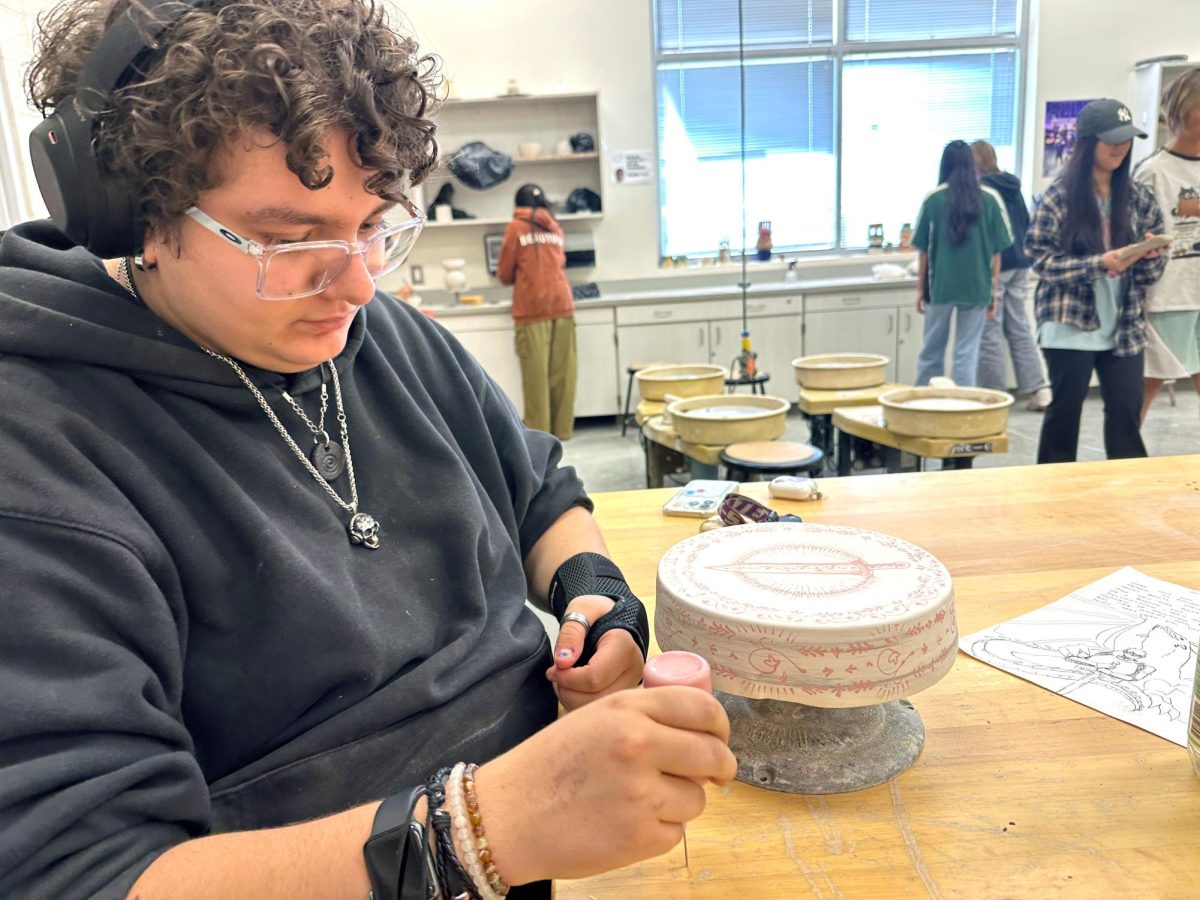 Torpis decorates a ceramic piece. “Since they've used almost all of the glazes in the classroom, I make test tiles as well for the kids so they know what it looks like,” Torpis said. “I'll show them different pieces I've made or different test tiles I've made, so they can see it and feel it, and they understand what it looks like.”