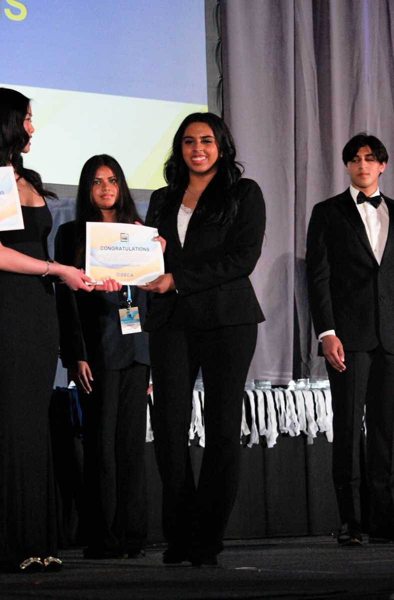 DECA president Harini Rameshbabu receives her award for collective school-based enterprise. “It's definitely a different environment,” DECA member and freshman Nikita Kulkarni said. “Ms. Dillon usually gives us the guidance we need, but this time, a lot of students just showed up for each other. I think we did pretty solid, even though we missed her presence.”
