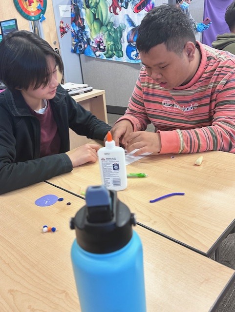 Senior Ray Tong and special education student and junior Clark Bogosh collaborate on an art project during a Bulldog Crew meeting. “A lot of the activities that the board comes up with have been really well received, and all the students seem to really enjoy doing it,” extensive support needs education specialist Desiree De Santos-Shaffer said. “They really look at the whole picture of what they can do and what people are feeling, and art has been a really big part of what we do as well.”