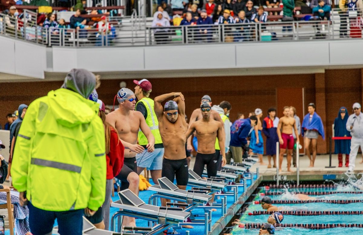 Before his event, senior Brian Nguyen stretches as he prepares to dive into the pool during one of his last meets and opportunities to bond with his swim teammates. “I feel like I've grown more out of the pool, and learning to be a part of a team that really bonds with each other well. And you know, we all hang out. We're good friends,” Nguyen said.