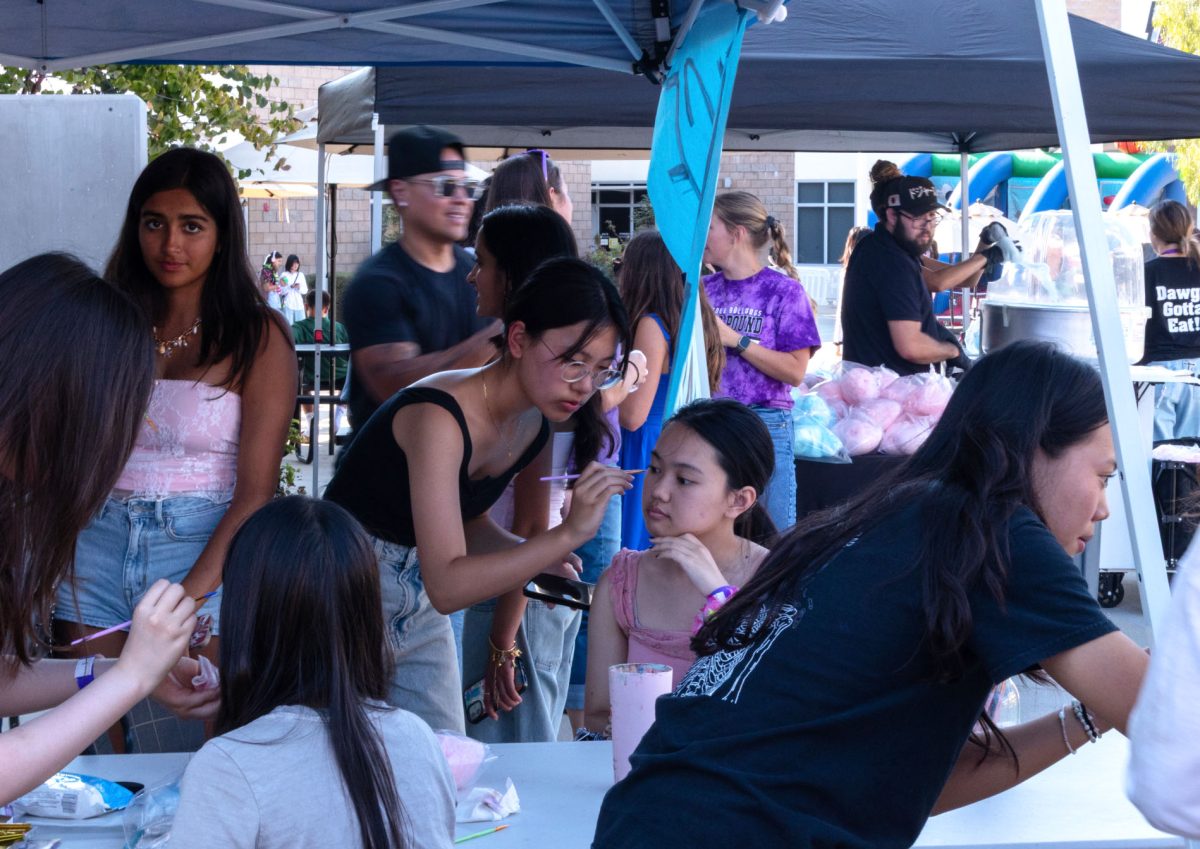 Students eagerly receive face paint at the back-to-school tailgate. “The tailgate is definitely a good way to welcome the students of Portola and bring people together,” junior class president Lauren Slade said. “Seeing all of these people have fun makes me feel good as a member of ASB who put a lot of work into this event.” 

