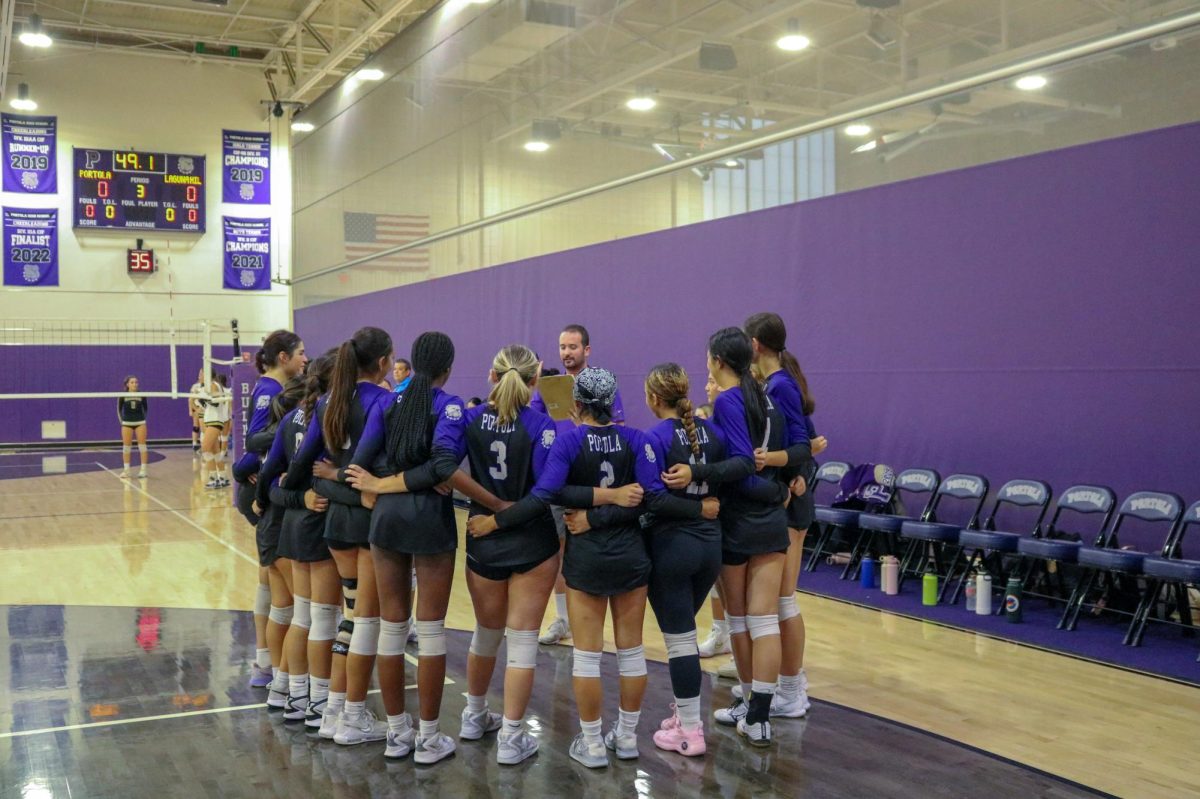 The girls volleyball team huddles during a game during the 2024-2025 season. “I think our team dynamic has grown so much this year,” captain and senior Paige Ingles said. “We have so many people who play multiple positions, and it makes our whole team able to win the game for us.”