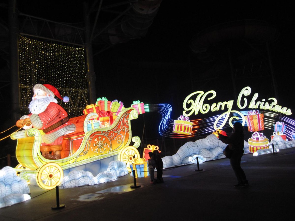 Families pose for photos in front of illuminated lantern displays featuring Santa in a sleigh and the message “Merry Christmas” at the Dream Glow Festival. “My favorite part during the event was the Santa display near the entrance because it felt like Santa was personally welcoming me and [set] a cozy mood,” junior Christine Choi said.