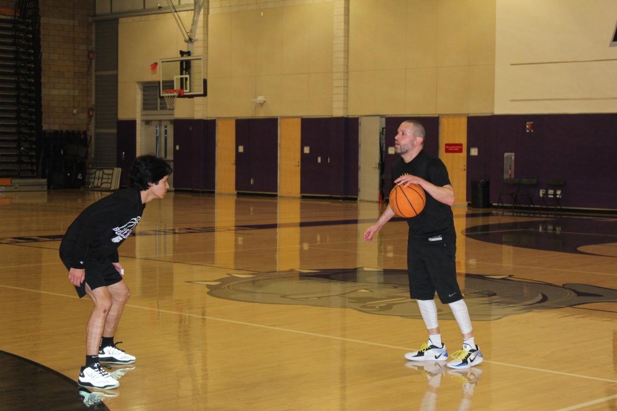 Sophomore Eli Gutierrez guards his father, Stephen Gutierrez during their morning basketball game. As the basketball group expands to include staff members from other schools, such as Gutierrez’s father, players can count on having enough members to fill the court each time they meet. “The expectation is that you are going to be there, and you can depend on those people to show up and play,” Ralston said. “There's the consistency I can always depend on.”