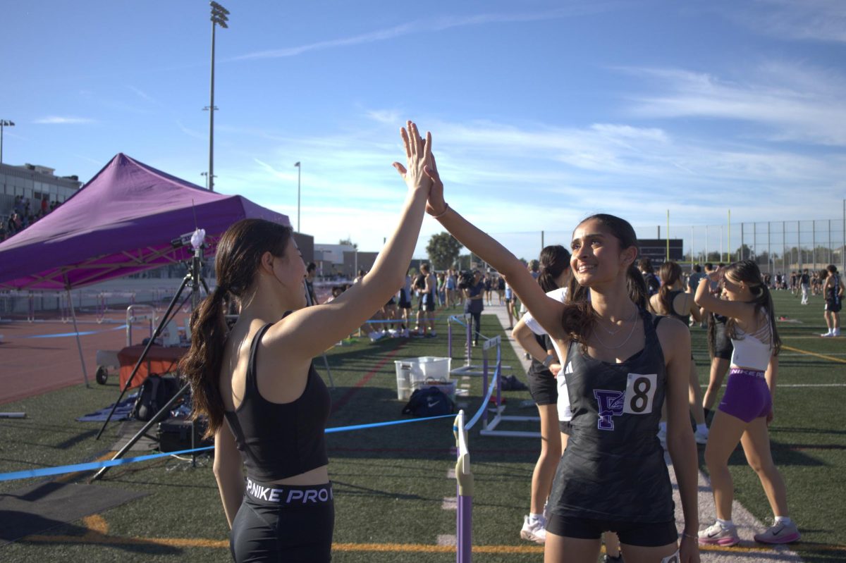 Varsity distance athletes, sophomore Ahana Bhat and junior Karlyna Chokry high-five after Bhat ran the varsity 1600-meter run. “Pushing your teammates to do better, carrying each other throughout the workouts and staying together during the long runs is just what pushes us forward as a team and as individuals,” Bhat said. 