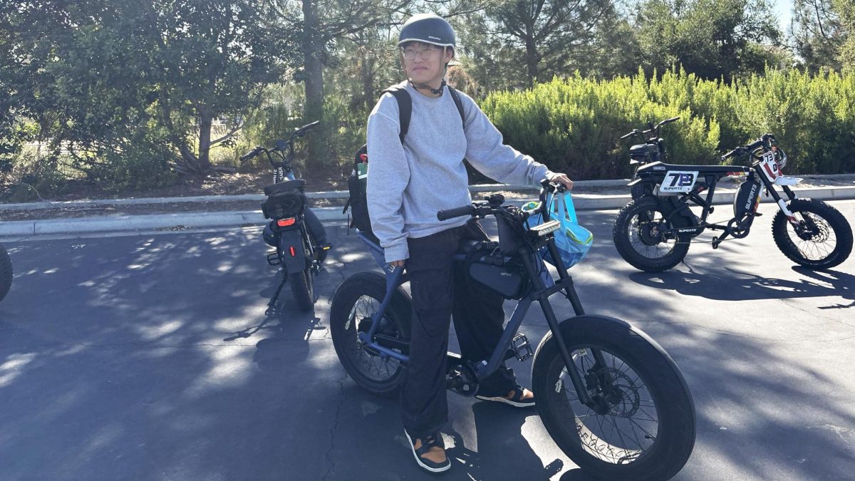 Junior Hyunbeen Jung wears a helmet, preparing to head more from the Portola High parking lot. “With the new e-bike rules, it’s important to wear a helmet and follow safety guidelines every time you ride,” Jung said.