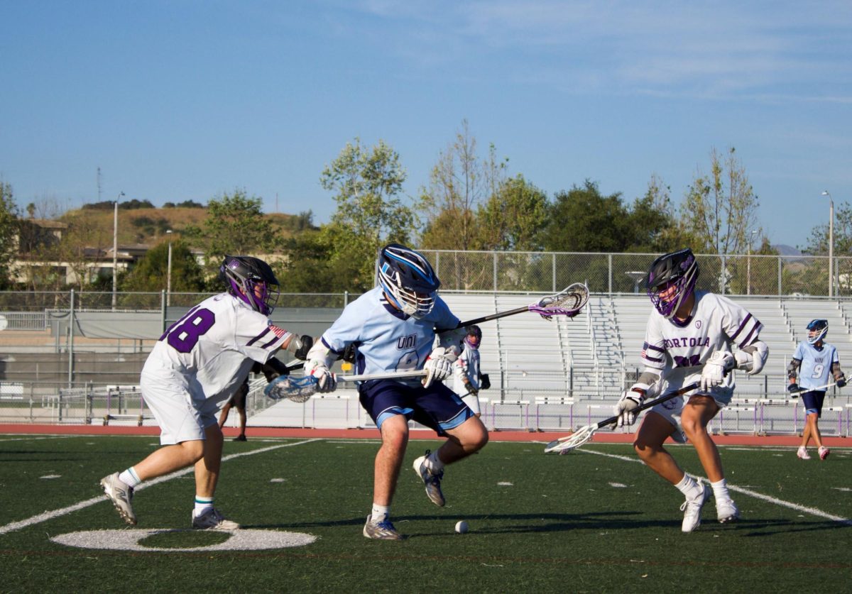 Defender and sophomore Cole Schatz and midfielder and sophomore Enzo Kwan fight for the ball against an offensive University High player. “We’ve done a lot of development on the wall and are getting good stick skills,” Co-head coach Colin O’Connor said. “That’s something we didn’t have [before], we’ve done a really good job [playing] defensively and offensively.”